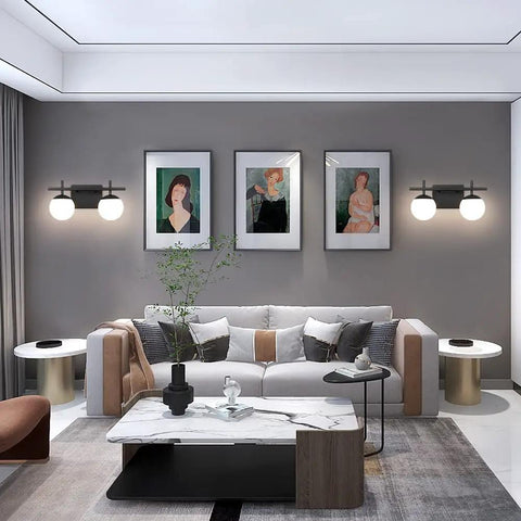 Two Light Black Vanity Light Fixtures With White Frosted Glass Globes in a modern living room with gray walls and art pieces
