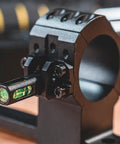One Piece Bolt Action Scope Mount With Thirty Mil Medium Rings For Remington Seven Hundred Short Action showing level bubble and structural support.