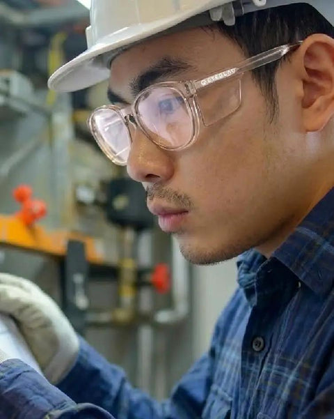 Heavy Duty Z87 Plus Safety Reading Specs With UV400 Side Shields And Impact Resistant Lenses Built Tough For Jobsites And The Daily Grind Featuring One Five X Clearfall Magnification worn by a man inspecting machinery.