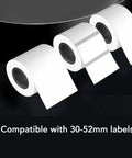 Cool Retro Label Printer With Bluetooth 5.0 Connectivity And Compact Design Perfect For Home Office Organization Tasks Features Inkless Thermal Printing Technology Compatible With A Range Of Paper Widths From Thirty Two Millimeters To Fifty Two showcasing rolls of white label paper compatible with 30-52mm sizes.