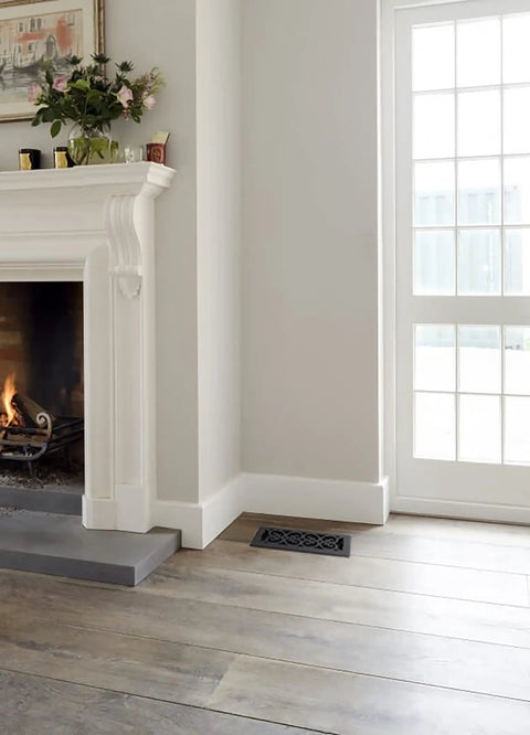 Living room with Scroll Design Floor Register 4x10 in Textured Black 8 Pack Decorative Steel Floor Vent on wooden floor near fireplace.