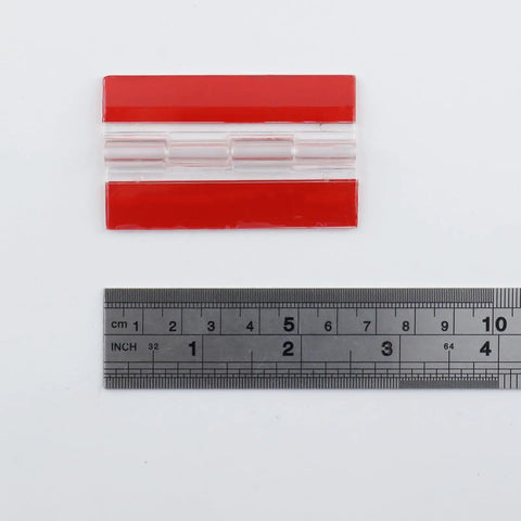 Self Adhesive Clear Acrylic Hinges For Cabinets Drawers And Furniture DIY Projects Transparent 65mm By 40mm with ruler scale showing size.