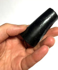 Hand holding a black 1 1/8 inch heavy duty asphalt plug for driveways and pavements, shown in close-up view.