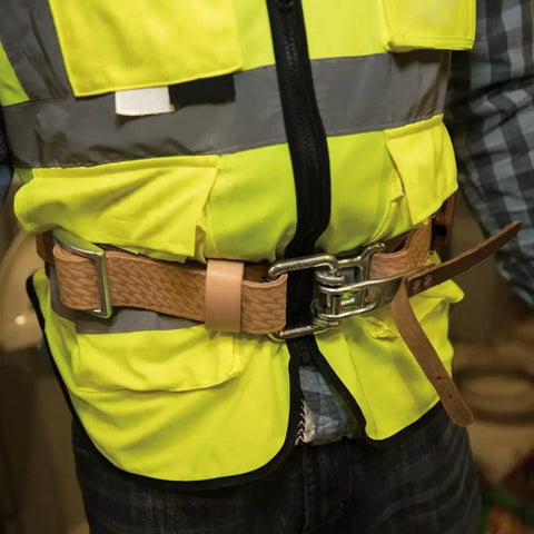 Person wearing 22-Inch Leather Cushion Belt Pad with Sponge-Padded Liner for Comfort over high-visibility vest.