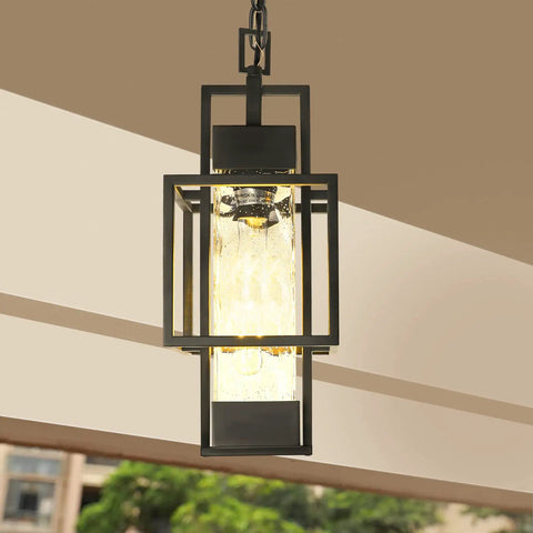 Top Tier 15 Inch Outdoor Indoor Pendant Light Featuring Heavy Duty Black Metal And Thick Water Seeded Glass hanging in foyer.
