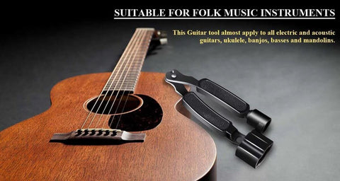 Guitar string winder, cutter and pin puller - black 3-in-1 tool beside an acoustic guitar