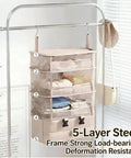 Heavy Duty Hanging Travel Shelf Bag Organizer For Luggage Suitcase With Ventilated Mesh Pockets And Water Repellent Nylon Fabric Badass Carry On Organizer In Purple hanging on a steel rack with folded clothes.
