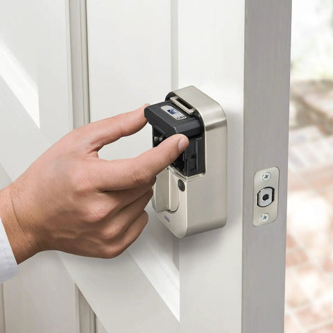 Hand installing Slick Satin Nickel Smart Deadbolt Featuring Bump Proof Touchscreen Keypad on a white door.