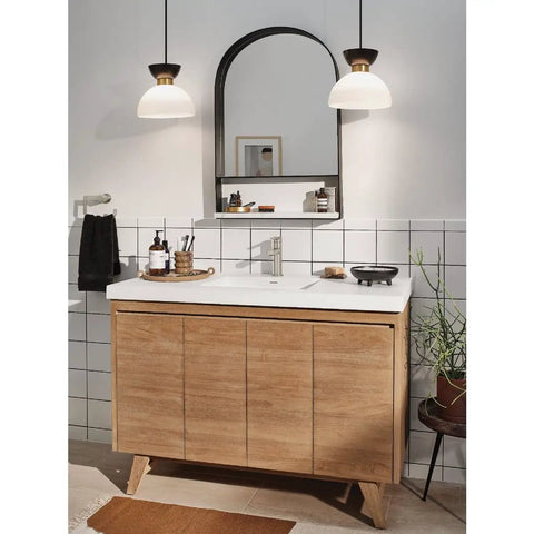 Modern bathroom with wooden vanity, wall mirror, white sink, and two pendant lights above. Tiled wall adds a sleek touch.