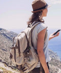Hiker with a beige backpack using 1 Inch Black Plastic Quick Release Parachute Buckles 30 Pack for Backpack Straps and Webbing Belts outdoors