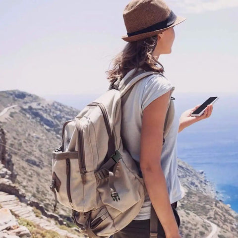 Hiker with a beige backpack using 1 Inch Black Plastic Quick Release Parachute Buckles 30 Pack for Backpack Straps and Webbing Belts outdoors
