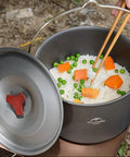 Ultralight Aluminum Hanging Camping Pot With Lid, 4.2 Quart Cookware For 4 To 6 People with rice and vegetables outdoors