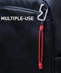 Badass Titanium Keychain Carabiner Multitool With Bottle Opener on backpack strap, featuring red paracord loop.