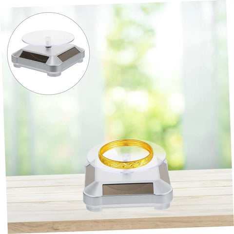 Didiseaon Solar Powered Rotating Jewelry Display Stand Decorative Rack For Watches Necklaces Bracelets Stable Electric Turntable Organizer Bedside Daily Use Auto Spin Light Show showing a gold bracelet on a solar-powered display.