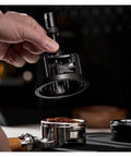 Slick Pro Grade Heavy Duty Adjustable Rotary Espresso Tamper And Coffee Distribution Spoon Levels Grounds Smooth For 51Mm 54Mm 58Mm Portafilters, in hand above coffee grounds.