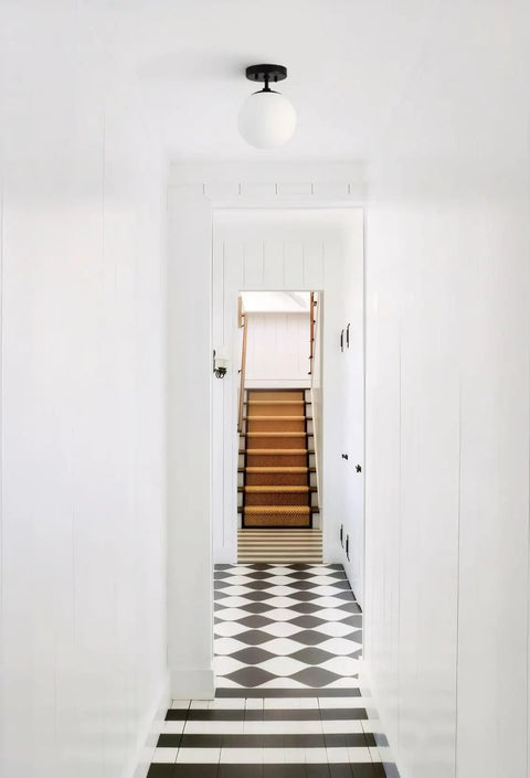 Cool Soft Black Semi Flush Mount Ceiling Light With Frosted Glass Shade in white hallway with geometric floor tiles