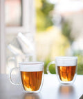 Double Wall Borosilicate Glass Mug Set Of Two Keeps Your Daily Joe Smoking Hot with clear design and amber beverage visible.