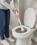 Slick Modern Toilet Plunger With 19 Inch Handle And Gray Rubber Cup Kicks Clogs Fast And Features A Snazzy Three Piece Design in use over toilet.