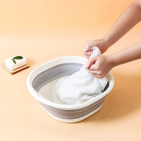Small Ultra Handy Foldable Washbasin Set in use, hands washing a cloth, showcasing collapsible RV sink for camping.