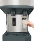 Heavy Duty Countertop Nugget Ice Maker And Touchfree Water Dispenser Cranks Out 500 Lbs Daily, filling a cup with nugget ice.