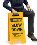 Caution Slow Down Pedestrians In Area Folding Floor Sign 25 By 12 Inches Plastic Black On Yellow Double Sided Sign in use