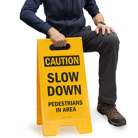 Caution Slow Down Pedestrians In Area Folding Floor Sign 25 By 12 Inches Plastic Black On Yellow Double Sided Sign in use