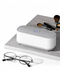 Portable Ultrasonic Jewelry Cleaner For Rings Silver Watches Retainers And Glasses Compact Countertop Machine beside glasses and makeup brushes.