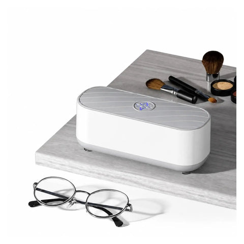 Portable Ultrasonic Jewelry Cleaner For Rings Silver Watches Retainers And Glasses Compact Countertop Machine beside glasses and makeup brushes.