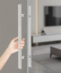 Double Sided 23.43 Inch Stainless Steel Barn Door Handle Bar Pull For Sliding Glass Shower And Entry Doors With A Grippy Ergonomic Back To Back Grip And Simple Push Pull Action For High Traffic Spaces. Close-up hand on double-sided stainless barn door handle
