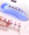 Two Sets Pink Nail Practice Stands With Magnetic Display Bases And Acrylic Nail Holders For Press Ons Includes Double Sided Tape For DIY Home Salon Tools Kit in use with UV lamp.