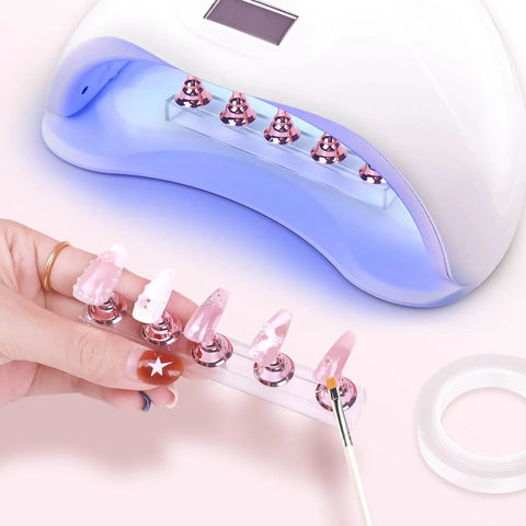 Two Sets Pink Nail Practice Stands With Magnetic Display Bases And Acrylic Nail Holders For Press Ons Includes Double Sided Tape For DIY Home Salon Tools Kit in use with UV lamp.