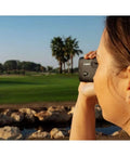 Person using Golf Rangefinder With 6x To 12x Zoom And Slope Correction, Image Stabilization, Built In Camera, IPX4 Water Resistant