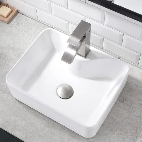 White Rectangle Ceramic Bathroom Vessel Sink And Brushed Nickel Waterfall Faucet Combo on counter with tile wall background