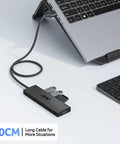 Four Port USB 3.0 Hub With 5Gbps Transfer connected to laptop and keyboard, showing extended cable and flash drives inserted.