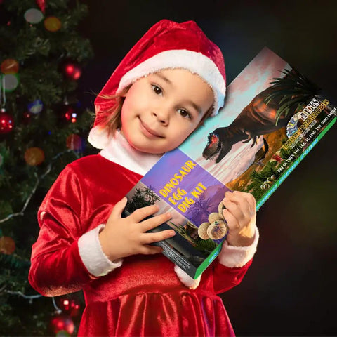 Child in red outfit holding Easter Dinosaur Eggs Excavation Kit For Kids Break Open 12 Dinosaur Eggs To Reveal 12 Unique Dinosaurs