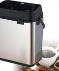 Electric Portafilter Cleaner Machine With Integrated Knock Box Fast Auto Espresso Backflush System Hassle Free Daily Cleaning Essential Heavy Duty Commercial Grade Silver Finish with black lid.
