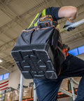 Person climbing ladder with Heavy Duty Tool Bag With Shoulder Strap And 40 Pockets In Bright Orange Interior For Fast Tool Access