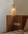 LQZCXMF Living Room Rattan Pendant Light 22.8" H Large Wicker Lamp Shade above a wooden headboard in warm bedroom setting.