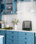 Modern kitchen with blue cabinets and Top Shelf 4 Pack Matte Black Cabinet Knobs, round drawer pulls on stylish drawers.