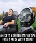 Man relaxing on a chair with Beast 10 Inch Oscillating Misting Fan With 1700 CFM And 20 MPH Air, Six Speed Settings, in front.