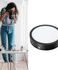 Stunning 360 Degree Rotating Display Stand With Electric Turntable, Adjustable Speed And Direction Control Via Remote, USB Powered 22cm Platform Featuring Colorful LED Lights For Pro Product Photography And Live Streaming, shown in use with photographer.