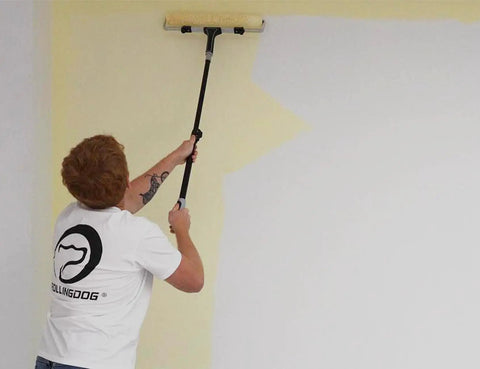 Painting a wall with the Pro Grade 20 Piece Paint Roller Set With Adjustable Frame And Extension Pole, using a long handle roller.