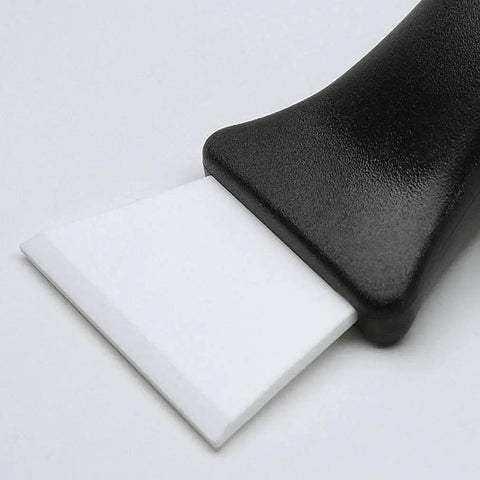 Close-up of ceramic utility and barbecue scraper with durable ceramic blade for home and kitchen surfaces.
