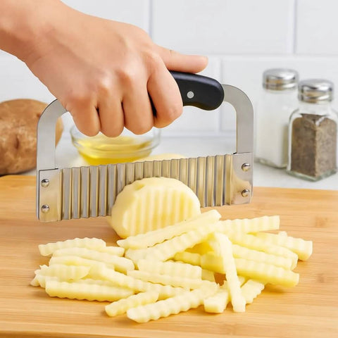 HIC Kitchen stainless steel crinkle-cut wave slicer with black handle slicing a potato into crinkle fries front view.