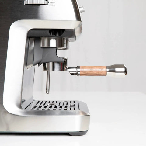 Bottomless 54mm Portafilter With Walnut And Stainless For Breville Espresso Machines attached to espresso machine.
