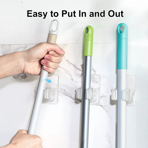 Close-up of wall-mounted Two Pack Adhesive Broom And Mop Holder With Rubber Grips, holding brooms in a kitchen setting.