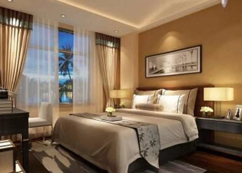 Elegantly decorated bedroom with warm lighting and artwork on the wall, featuring a cozy double bed and large window view.