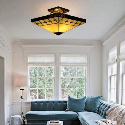 Tiffany Style Two Light Craftsman Semi Flush Ceiling Light with Antique Art Glass Shade in Beige in a cozy living room setting.