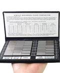 Hand holding Surface Finish Comparator Set Ra 0.05 To 12.5 Micrometers, 30 hardened steel blocks in open case.