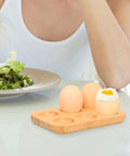 Organic Bamboo Deviled Egg Platter featuring six secure grid wells, eggs displayed on kitchen counter beside a salad.
